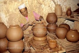 Image du Maroc Professionnelle de  Comme Safi est le chef-lieu de la poterie céramique marocaine, c’est à l’intérieur de son atelier que l’artisan tourneur travaille l'argile brute puis le transforme ainsi dans sa forme, souvent il s'agit d'objets de forme essentielle destinés à l'usage domestique. Quand l’objet est façonné selon le besoin une petit lame est utilisé pour donner à l'objet un aspect lisse. Souvent les artisans ont recours à leur dextérité afin de fignoler la décoration à Safi Vendredi 29 Août 1997.(Photo / Abdeljalil Bounhar) 